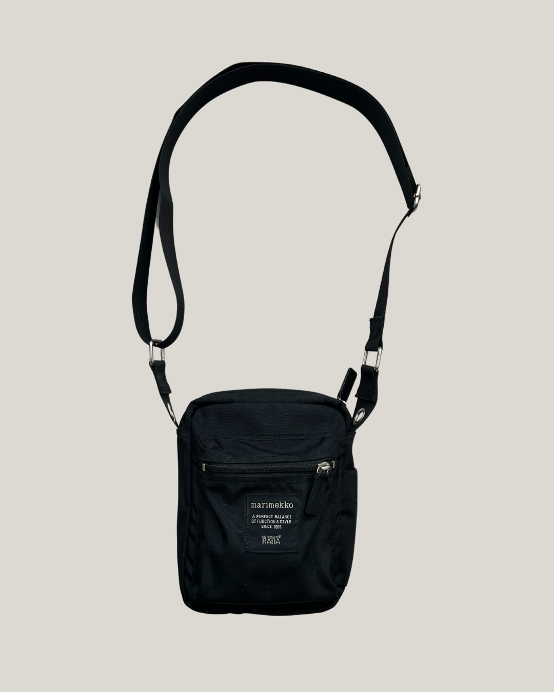 Black marimekko cash & carry shoulder bag on a beige background