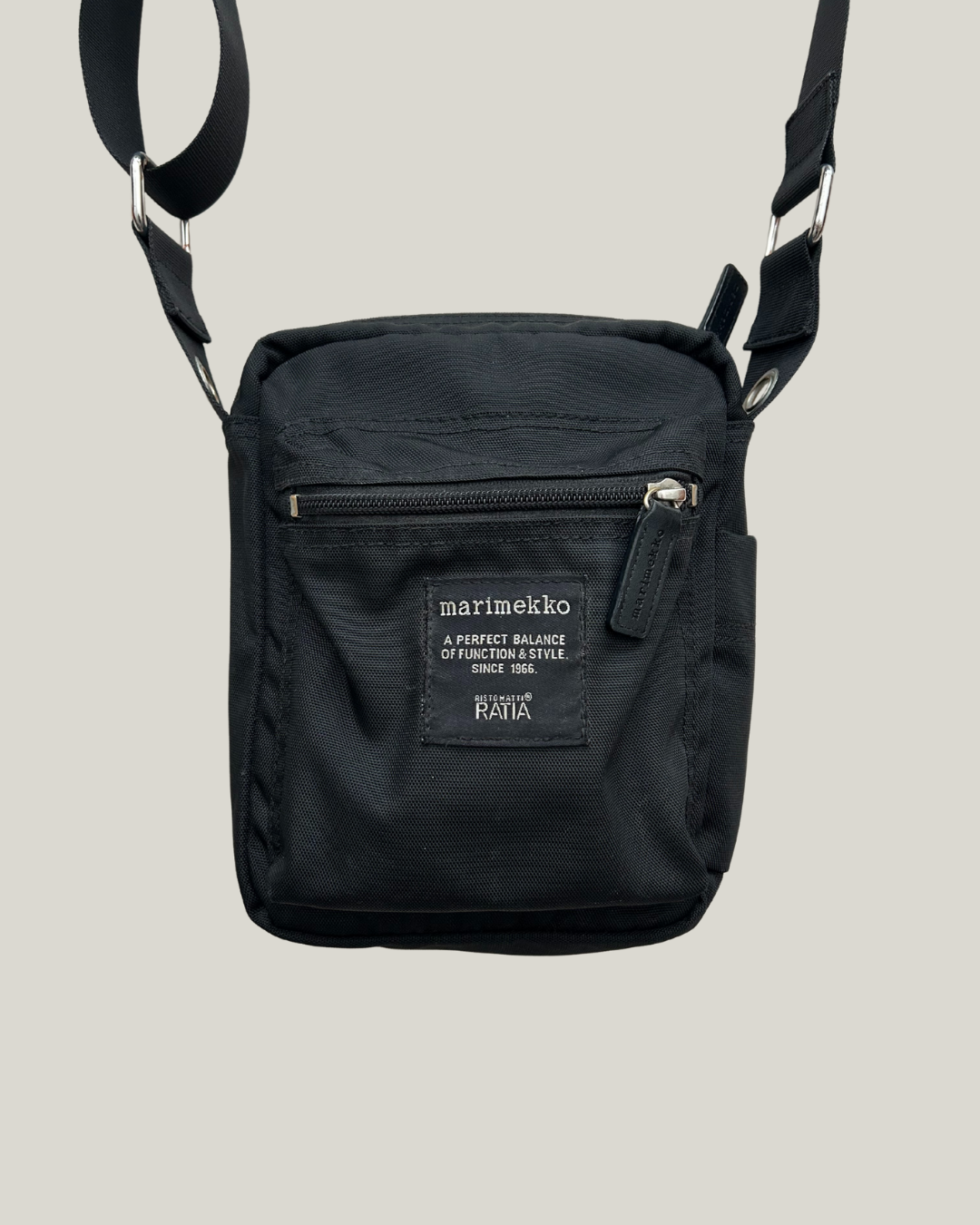 Black marimekko cash & carry shoulder bag on a beige background