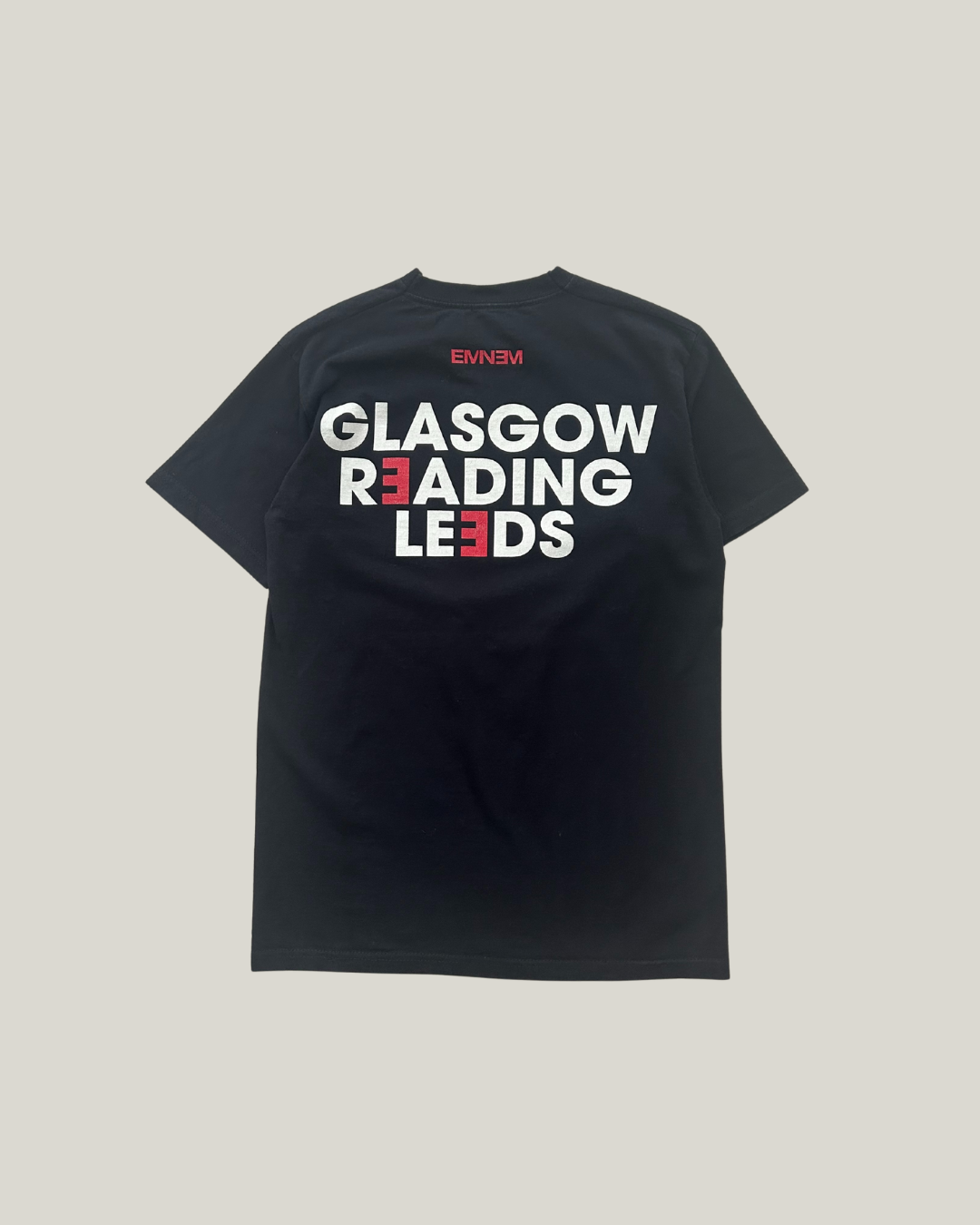 black eminem t-shirt and it says "Glasgow, Reading, Leeds" in the back