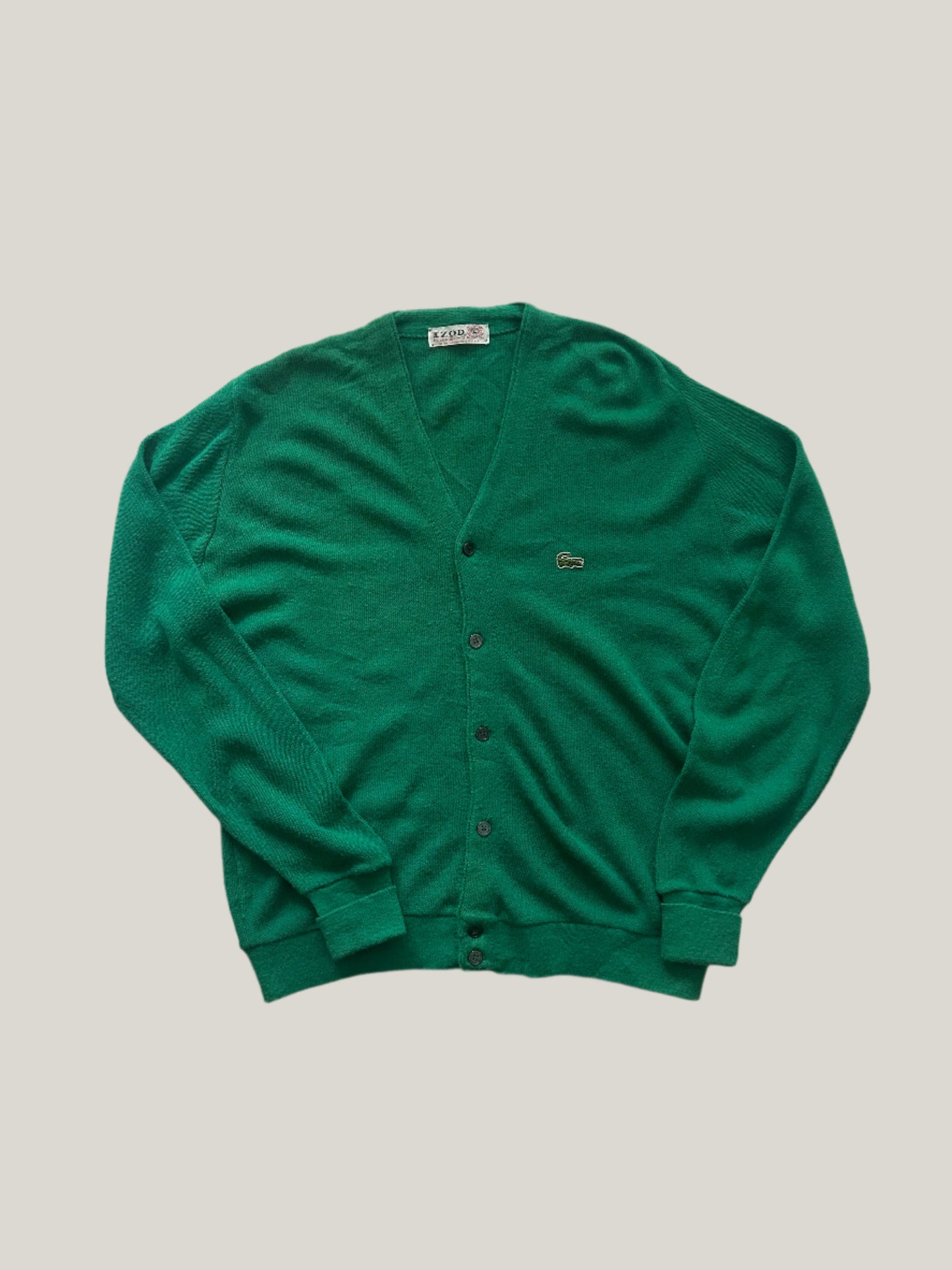 Green vintage Lacoste cardigan on a light gray background