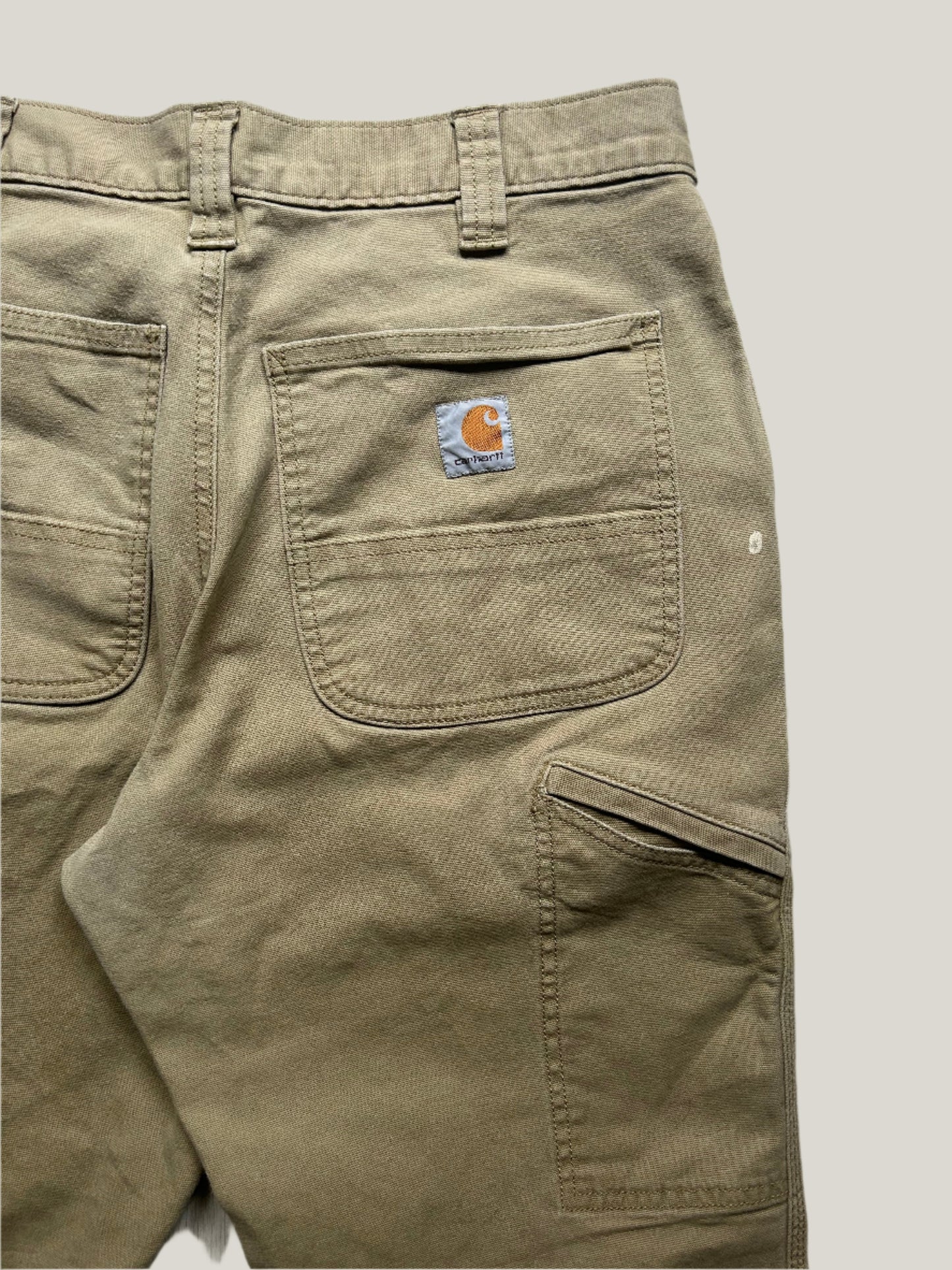close up of Khaki pants with a Carhartt logo on a back pocket