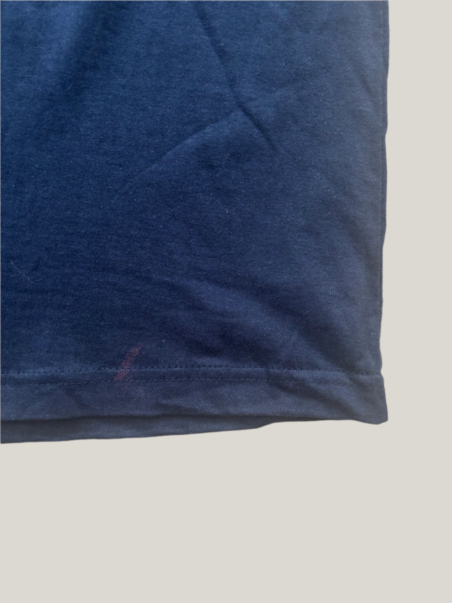 Light purple stain on a hem of a dark blue t-shirt