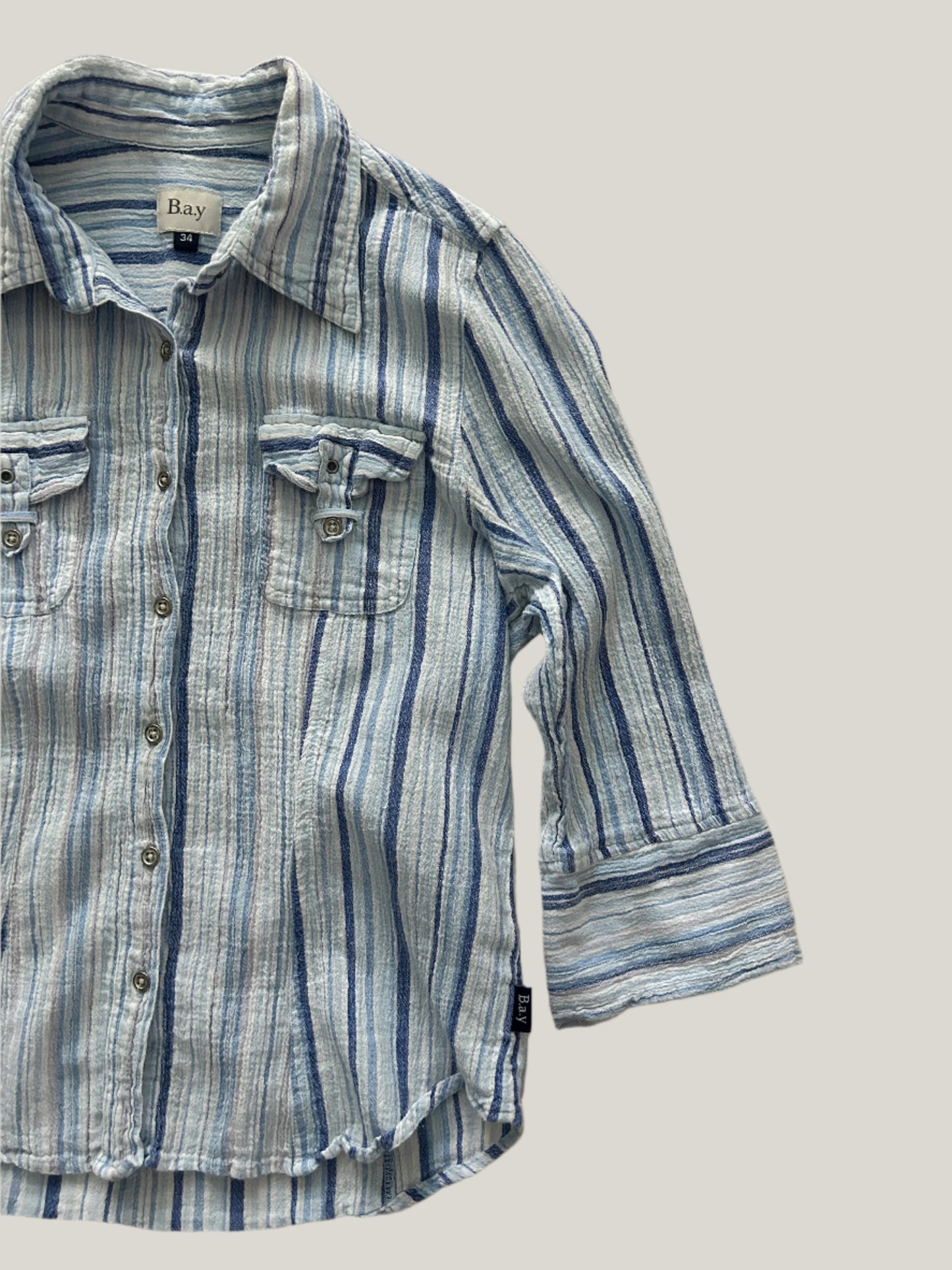 womens striped button-up shirt in different shades of blue with two chest pockets and 3/4 sleeves and collars