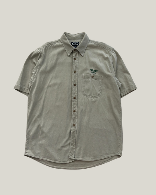 beige short-sleeve button-up shirt with a "mead safety" logo on a beige background