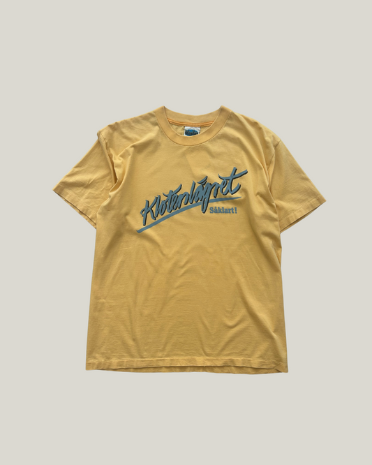 Yellow t-shirt with blue text on a beige background