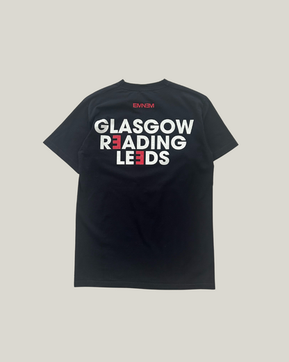 black eminem t-shirt and it says "Glasgow, Reading, Leeds" in the back