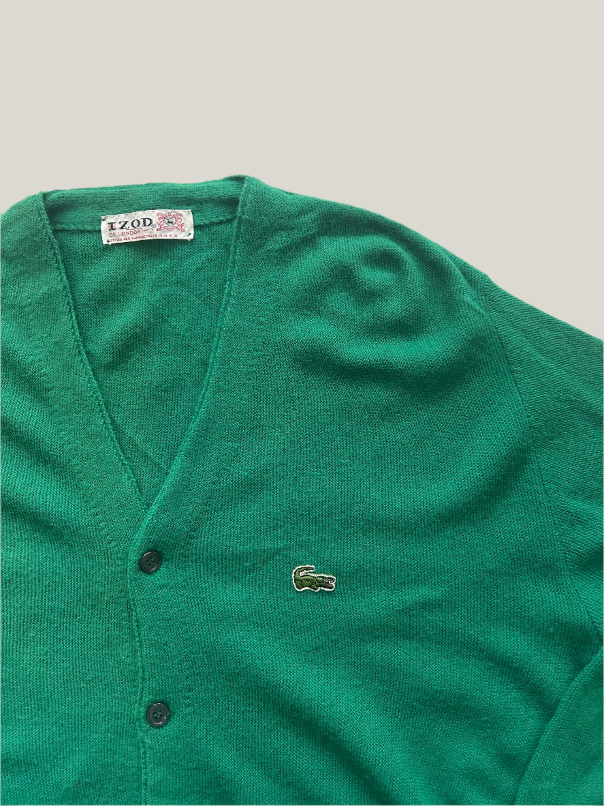 Green vintage Lacoste cardigan on a light gray background
