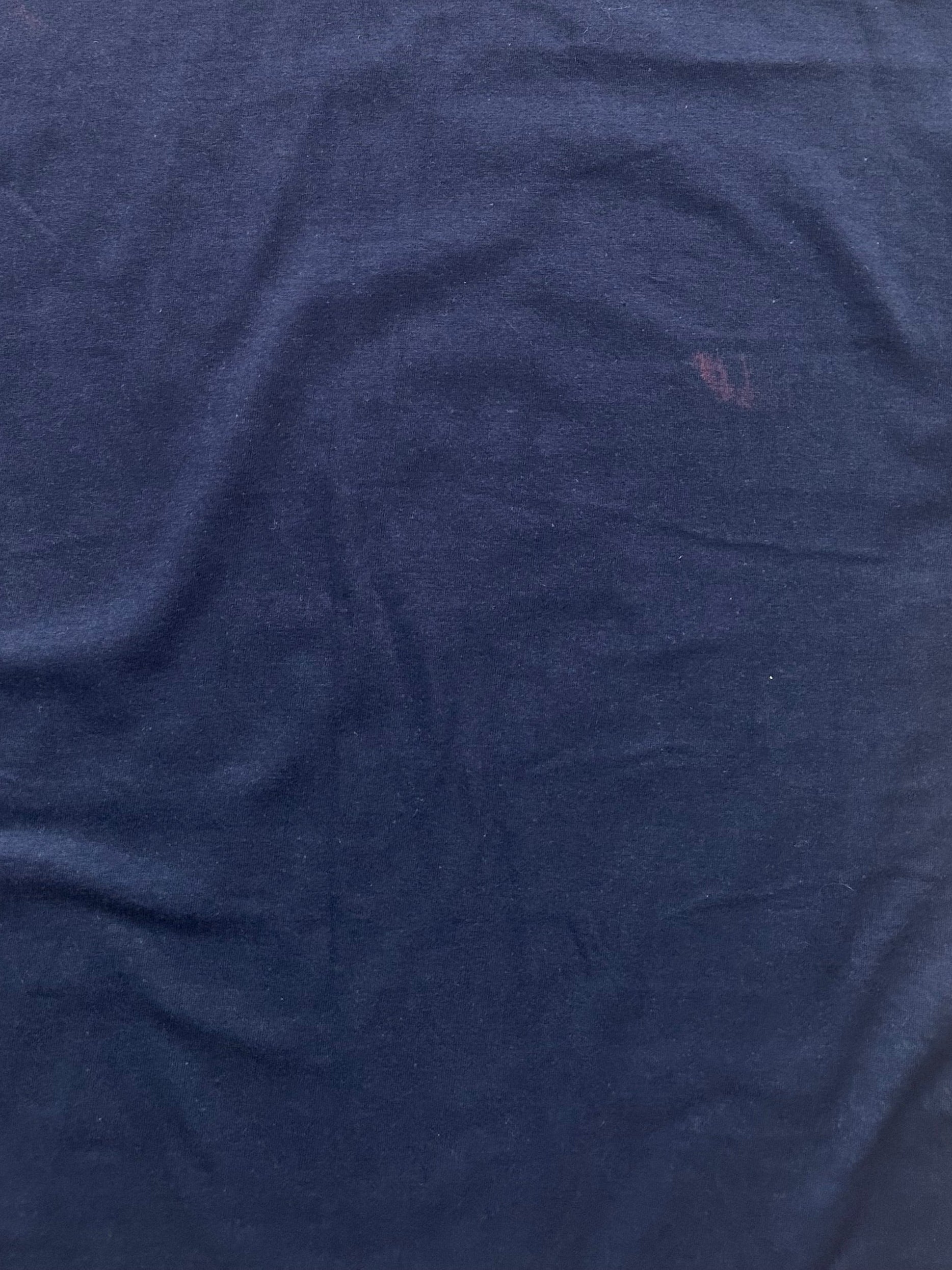 Light purple stain on the backside of the dark blue t-shirt
